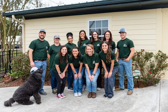 A group of people in green shirts and hats.