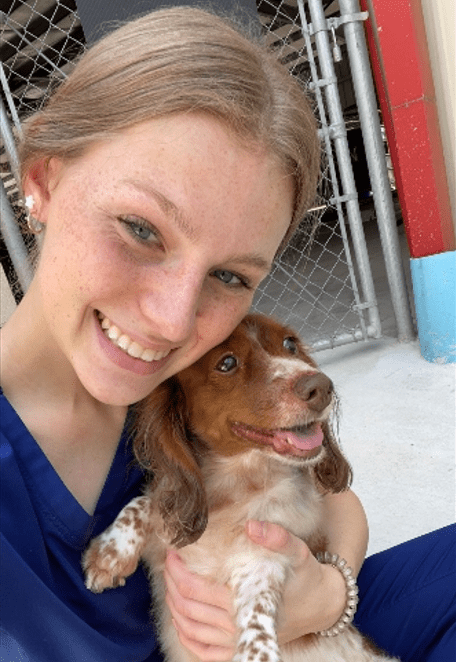 A woman holding a dog in her arms.